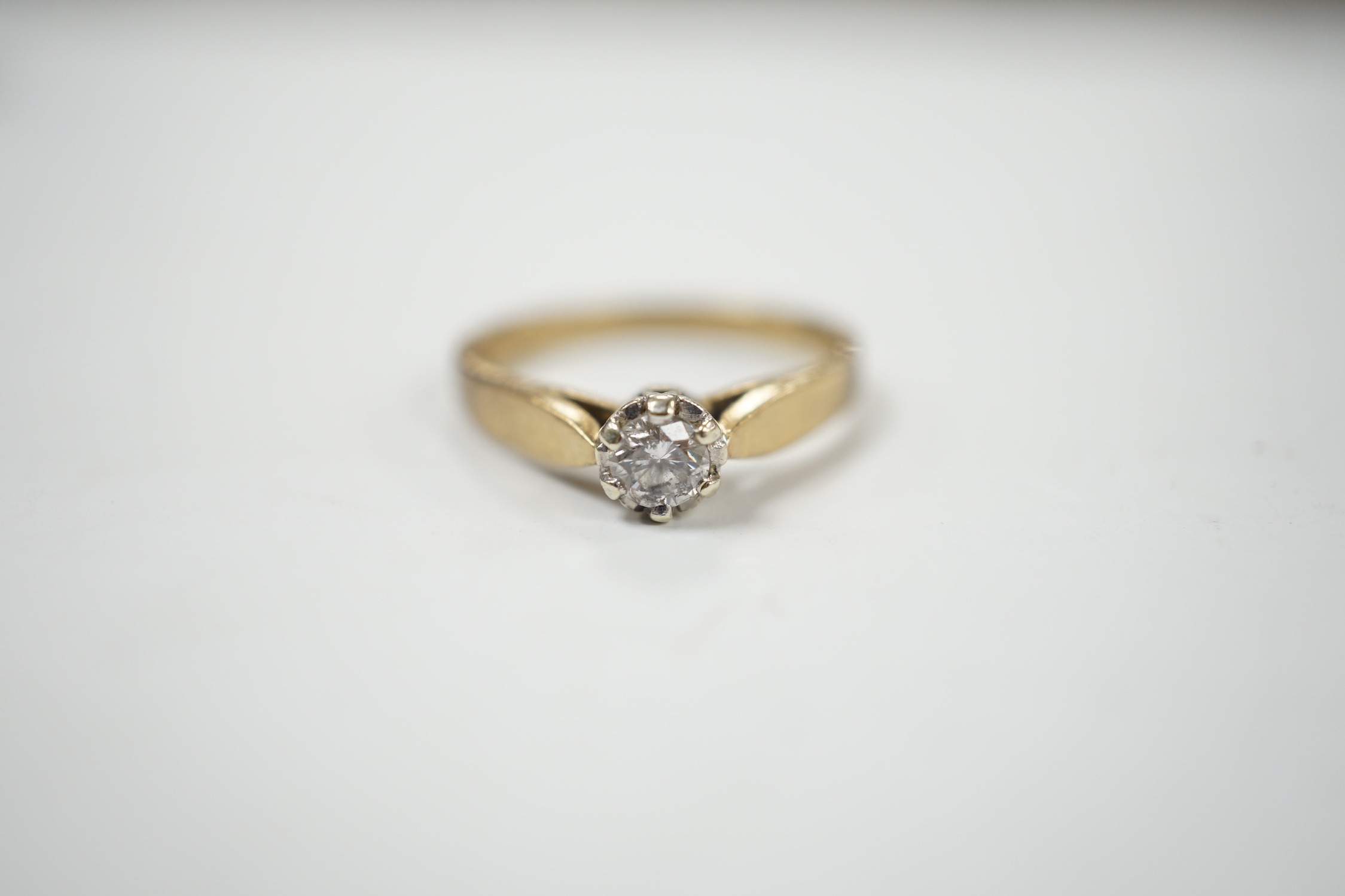 A yellow metal and solitaire diamond set ring, size N/O, gross weight 2.4 grams.